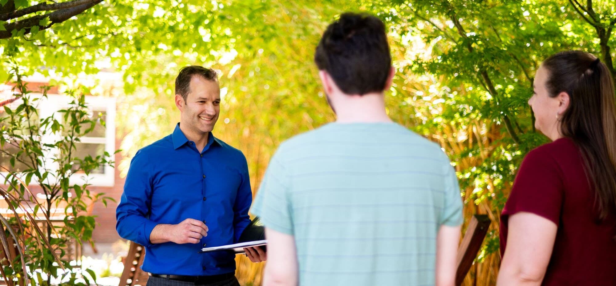Joseph Olson talking with buyers outside a home